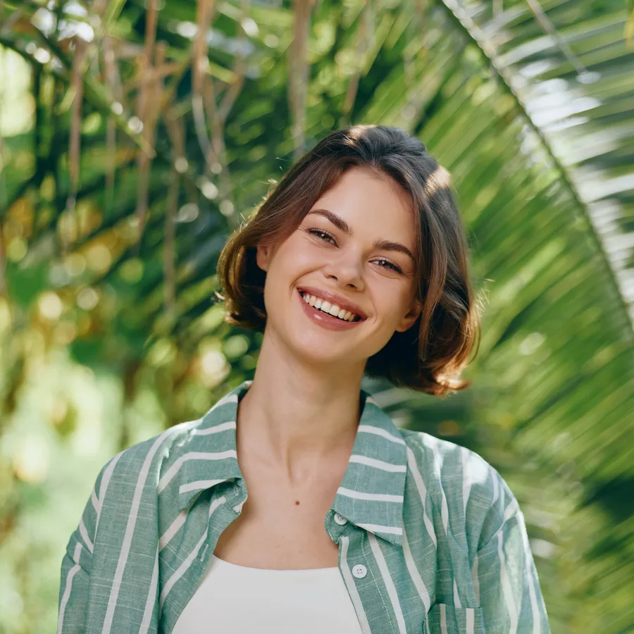 Woman smiling outdoors with a bright, even smile